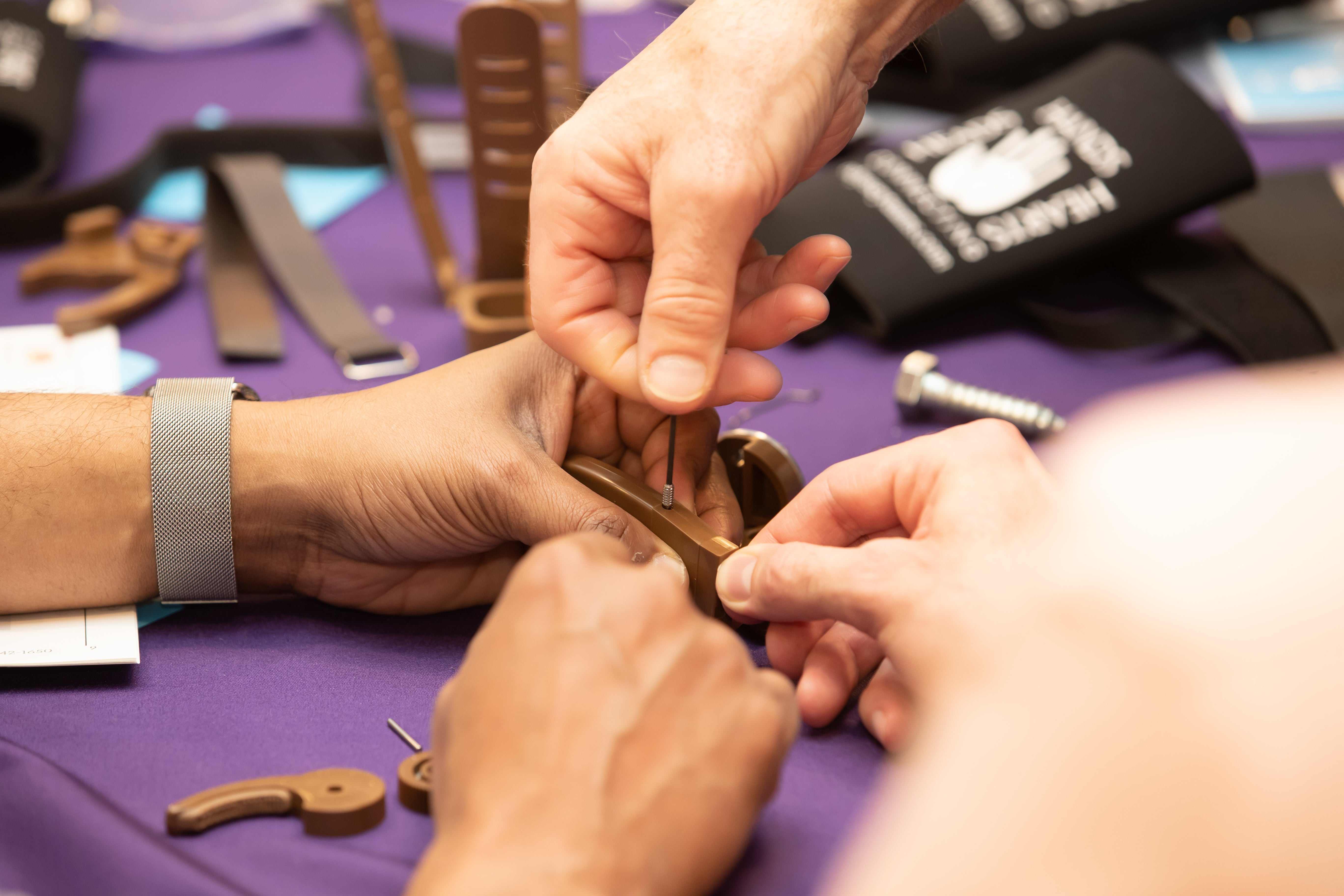 Schneider Electric leadership team building prosthetic hands in corporate workshop