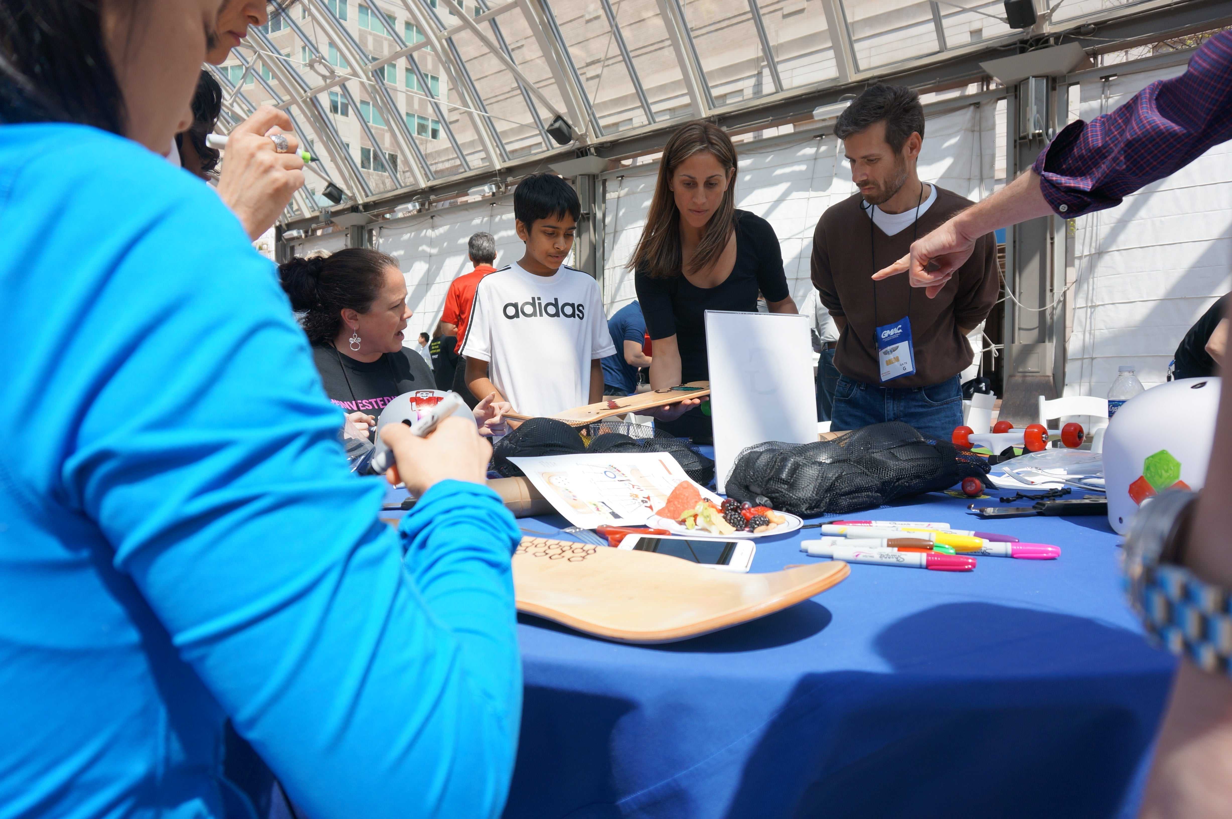 Corporate volunteer team-building event with adults and children building skateboards together
