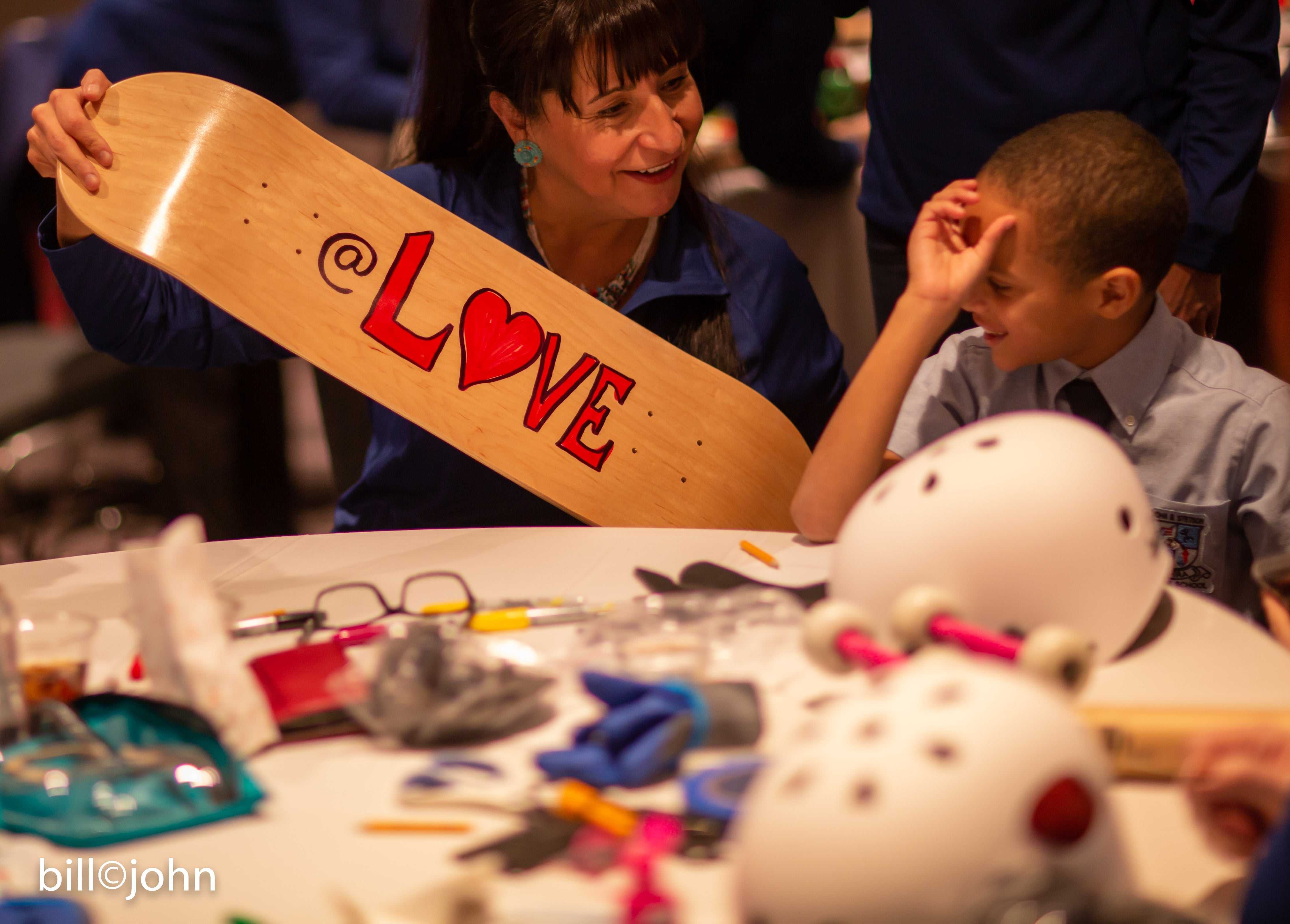 Adults and children building skateboards together during a Board Meeting event promoting connection and communication