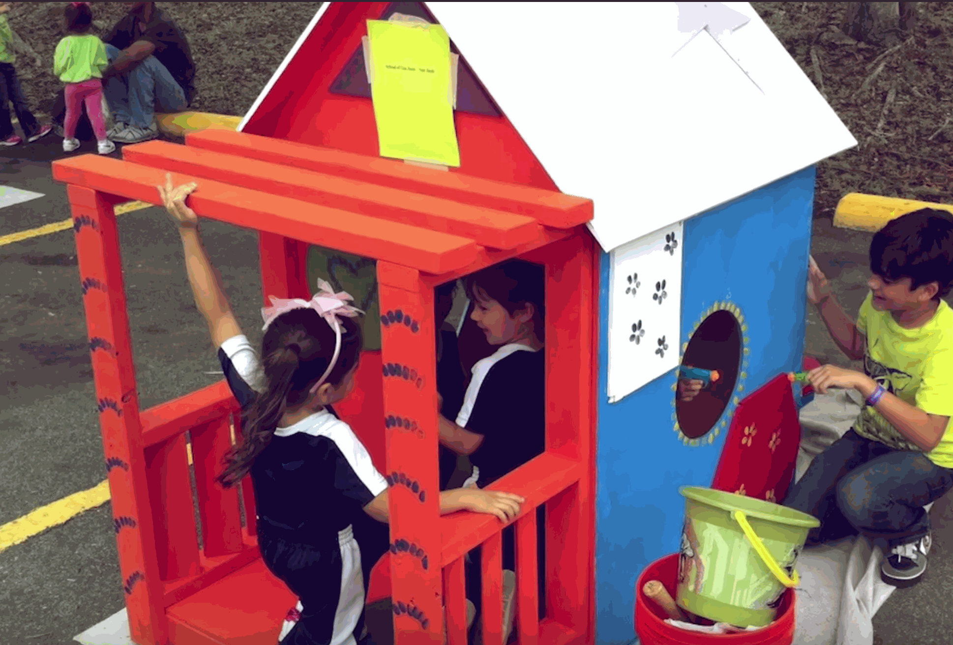 Children playing inside and around a colorful Playhouse Challenge™ Kit playhouse outdoors