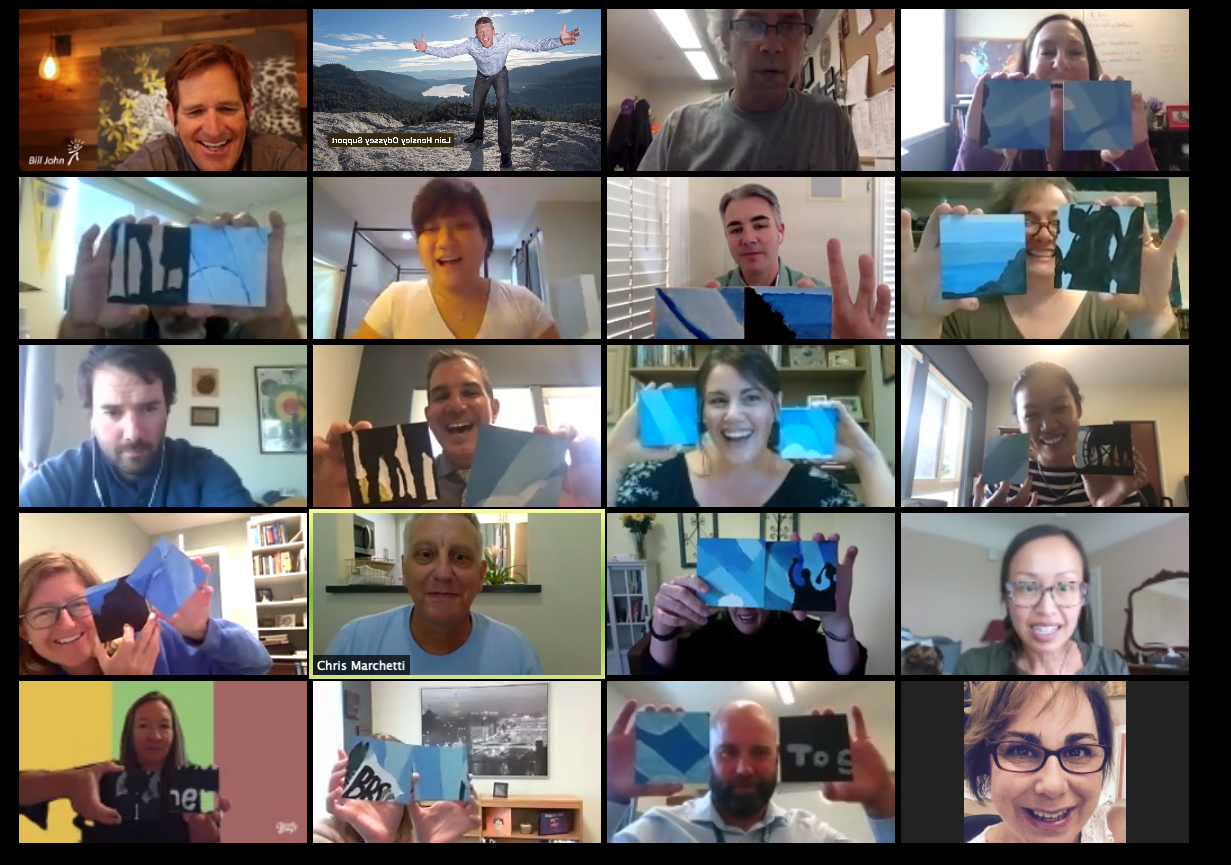 Grid of 20 video call screens showing people holding up blue cards with text on a screen.