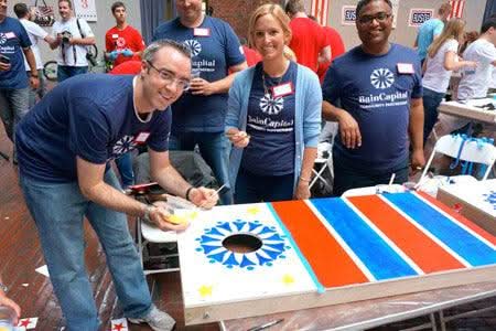 Team building with Play-it-Forward™ Kit assembling and painting cornhole boards for donation