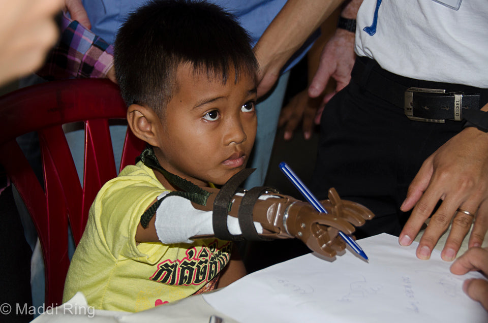 A young boy writing with his LN-4 Prosthetic Hand