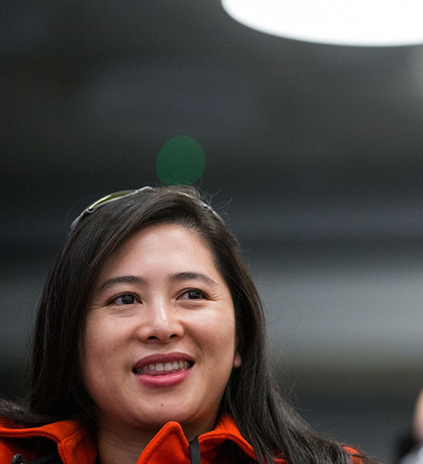 Woman with a green polka dot headband against a dark background