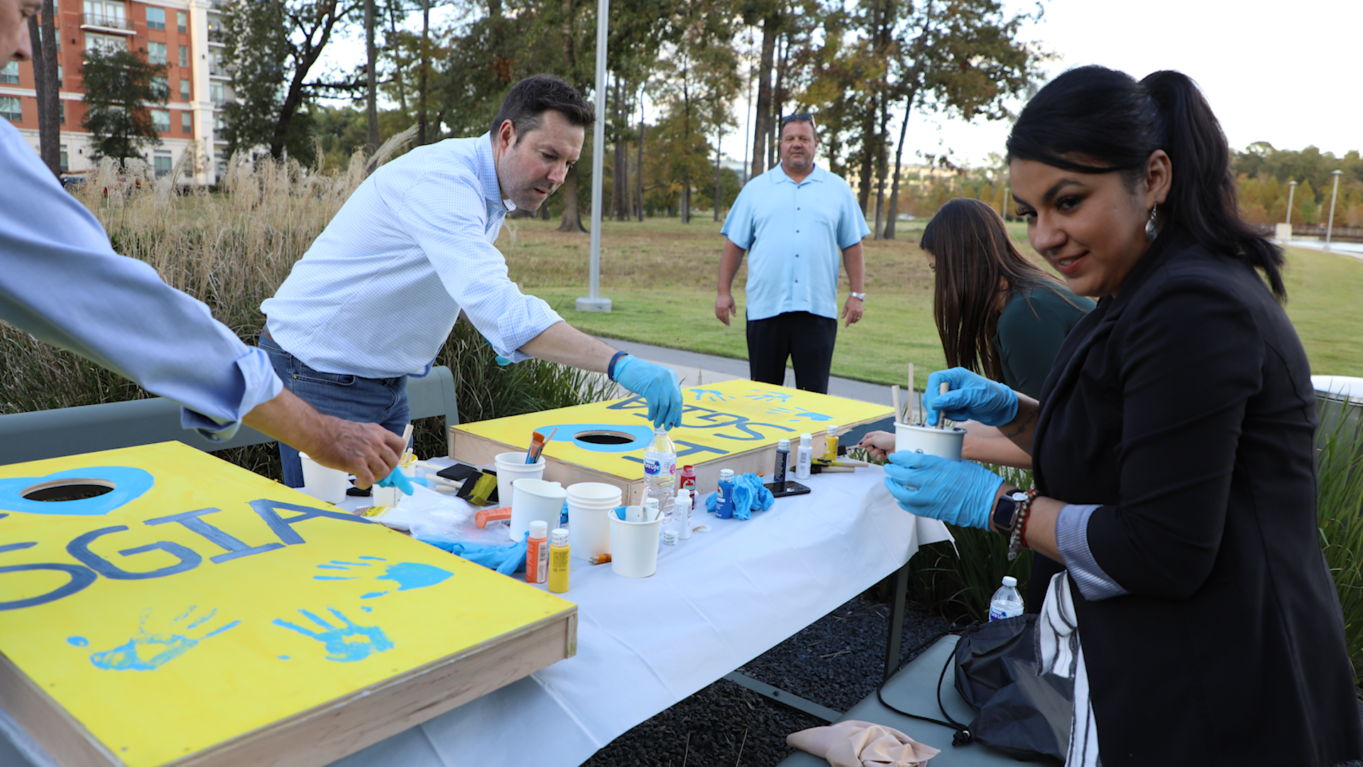 People participating in a cornhole game with 'Georgia' on the boards outdoors.