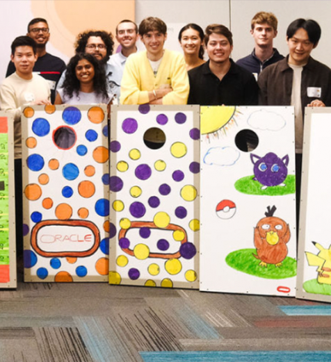 Group of people standing behind colorful paper bags with various designs