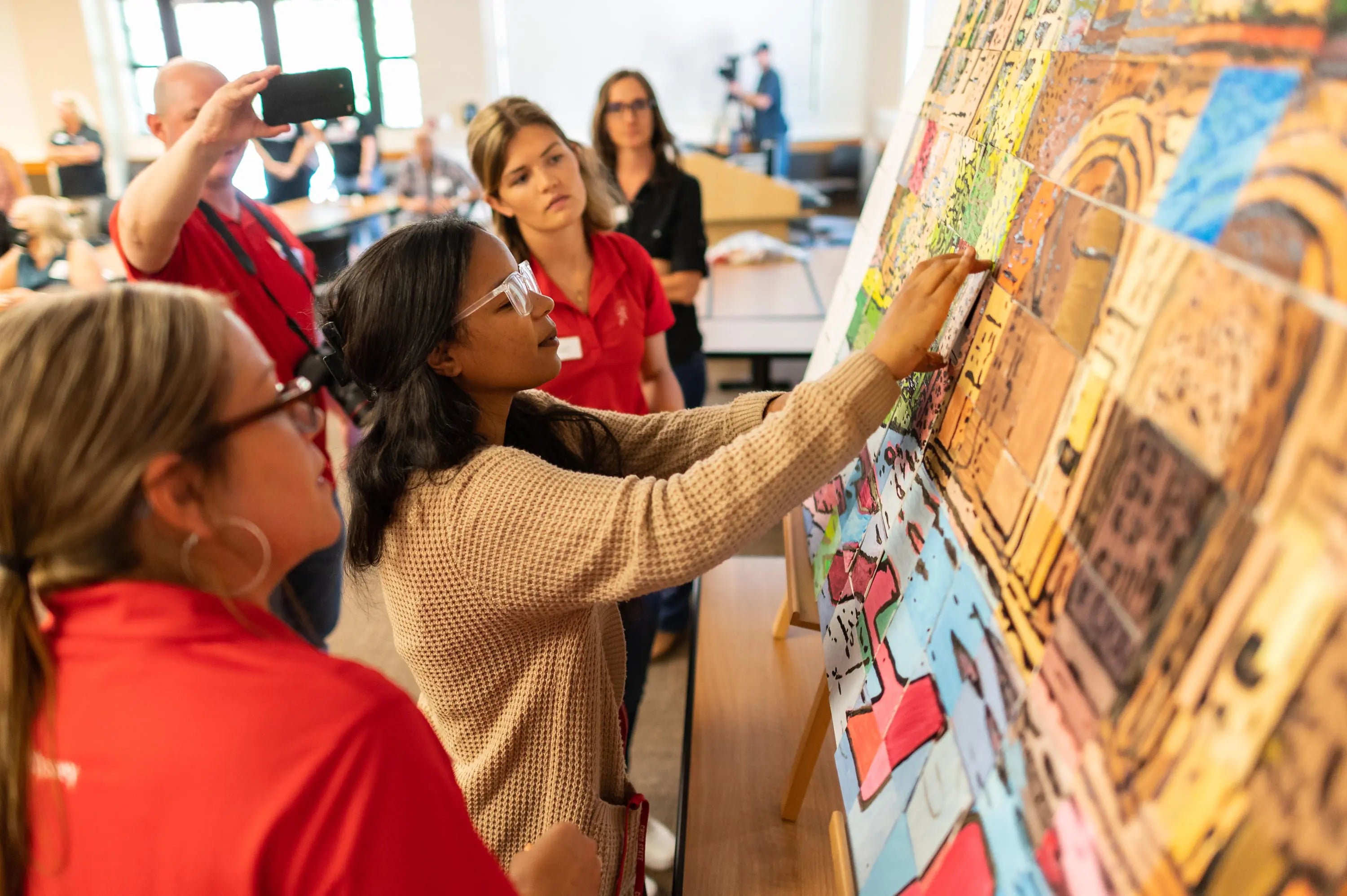 People interacting with a colorful display in an indoor setting